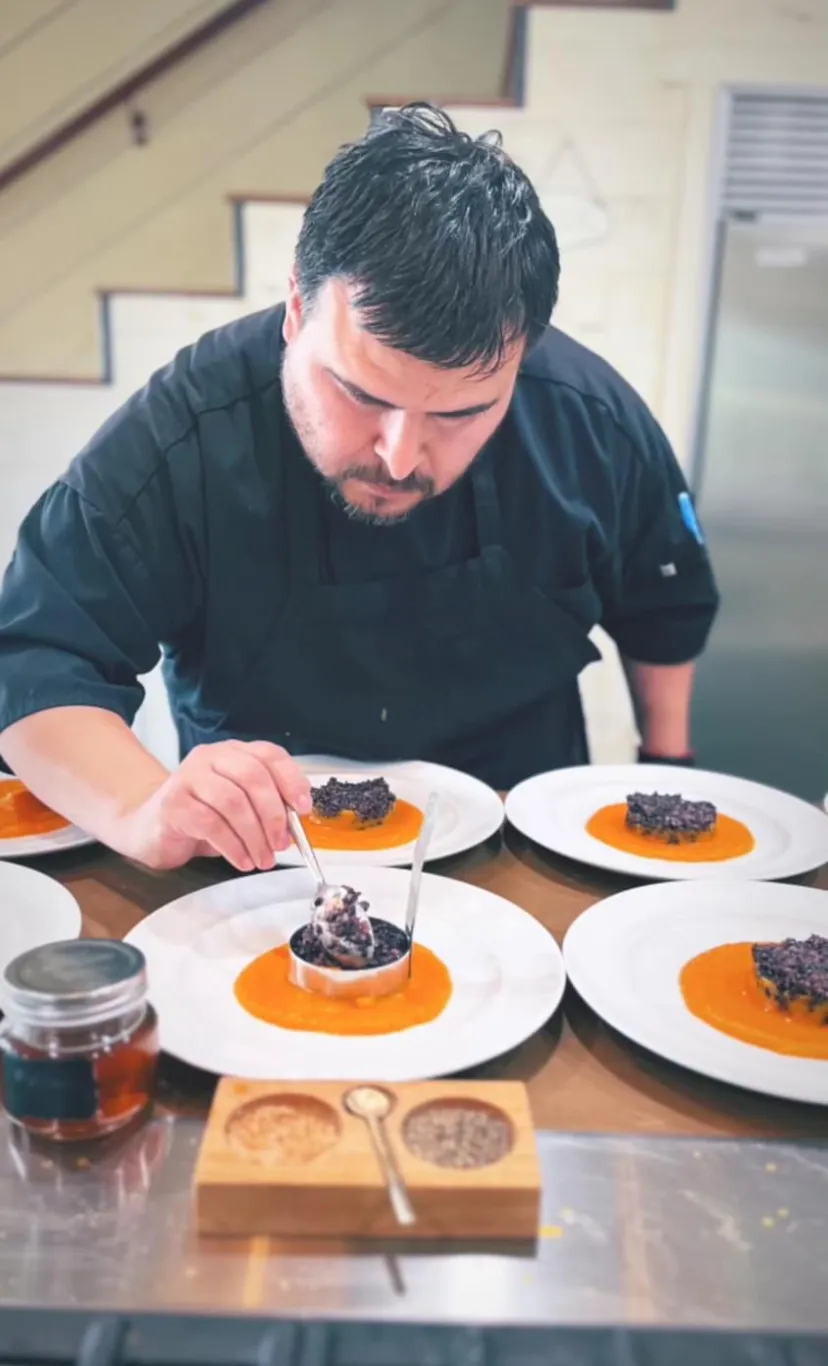 Chef of Grapevine Catering with a spread of plated courses